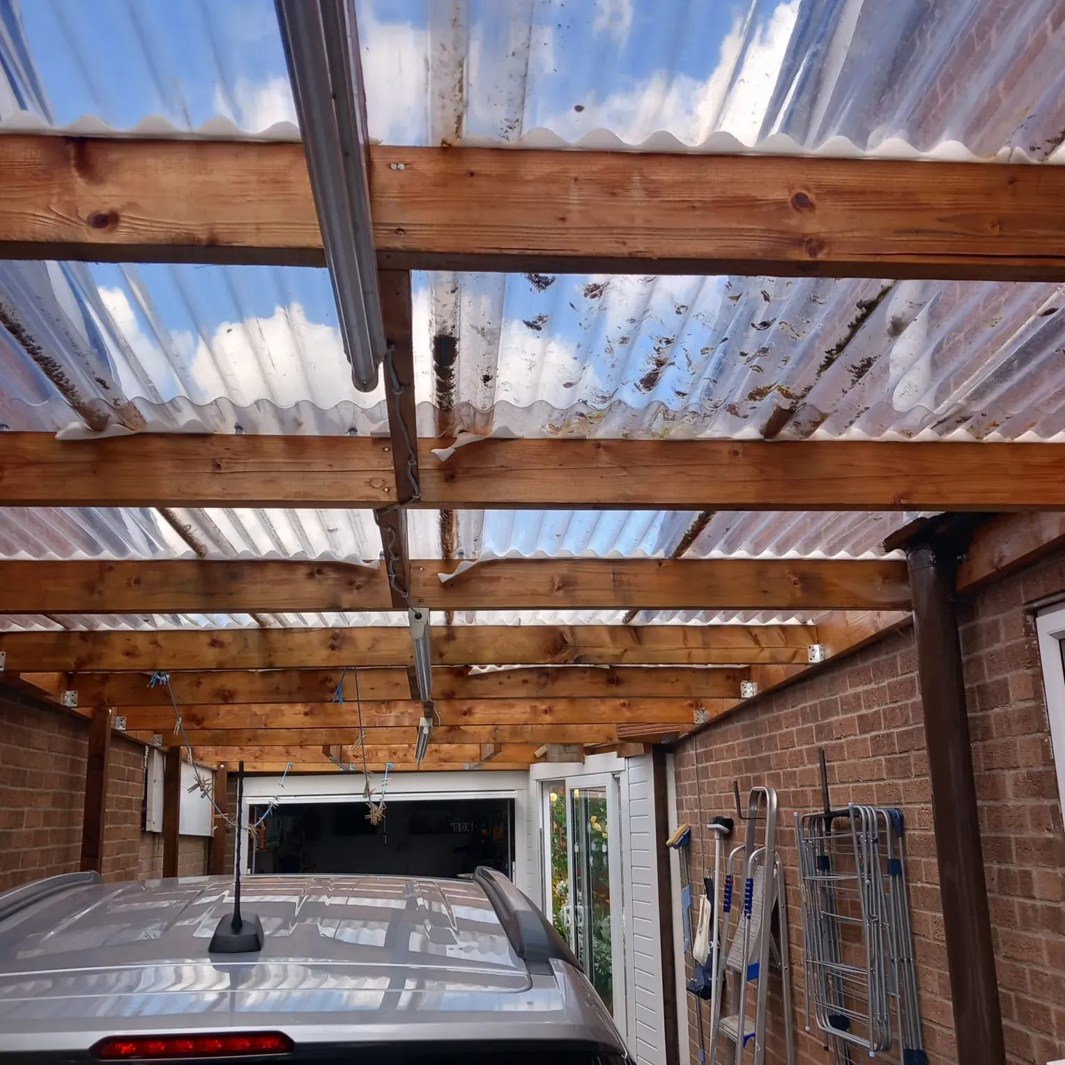 Carport roof with clear corrugated plastic sheeting and wooden beams in Leicester. 5 Star Roofing Leicester provides expert flat roof installations, new roofs for carports and extensions, and professional roof cleaning services across Leicestershire, ensuring durable protection and improved aesthetics.